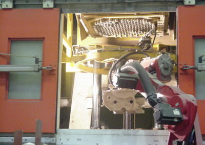 Automated robot removing castings from a vibration and casting station
